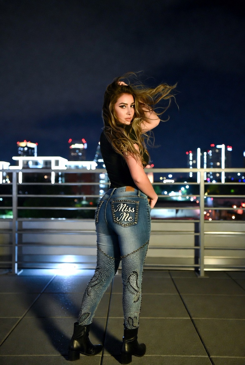 Woman wearing authentic Miss Me Crystal Embellished Skinny Jeans with sparkling crystal and sequin back pockets, high-rise skinny fit, premium stretch denim, and fashionable distressed detailing.